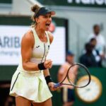 Jogadora de tenis Bia Haddad Maia comemorando um ponto com o punho em riste e dritando.