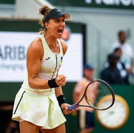 Jogadora de tenis Bia Haddad Maia comemorando um ponto com o punho em riste e dritando.